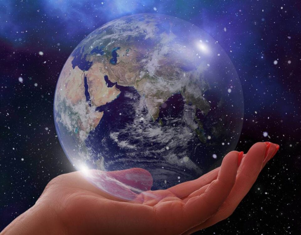 A human hand holding a transparent, glowing globe representing earth, set against a starry night sky background.