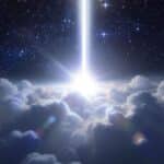 A beam of white light from the Cosmos illuminates through the clouds, creating a soft, radiant glow on the cloud formations that cover the earth below.