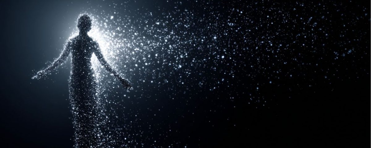 A person stands in darkness, radiating light from their body, creating a striking contrast against the black background.