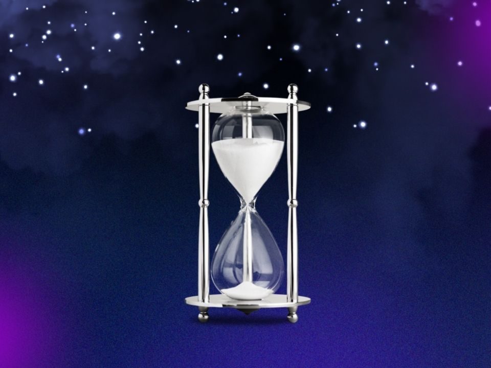 An hourglass filled with sand, set against a vibrant purple background, symbolizing the passage of time.